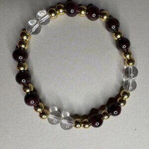 bracelet features a harmonious blend of red agate, clear quartz, and gold-tone